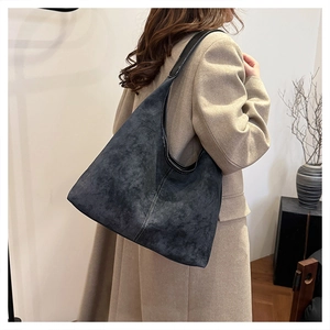 Close-up of retro matte hobo bag with distinctive vertical stitching and wide strap