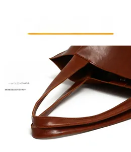 Detail view of reinforced stitching on the brown vintage tote bag with oil-wax texture