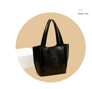 Detail showing high-gloss black oil wax leather texture and stitching on tote bag