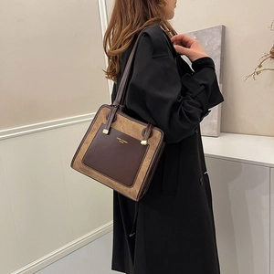 Retro khaki suede tote bag with brown leather pocket shown on model in black trench coat