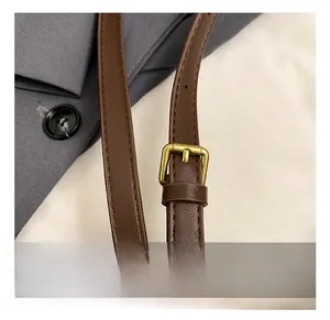 Detail of adjustable dark brown leather strap with antique bronze metal buckle
