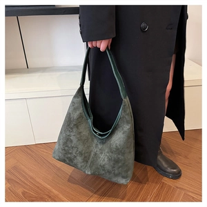 Detail showing high-capacity dark green faux suede shoulder bag with decorative stitching