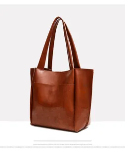Detailed side view of the brown oil wax leather tote bag with soft texture and handles
