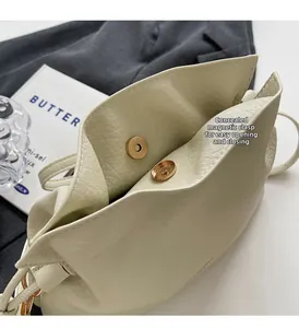 Gros plan sur le fermoir magnétique invisible d'un sac seau en cuir crème pour femme