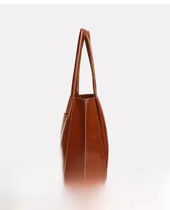 Side view detail of brown vintage faux leather tote bag showing pocket and stitching