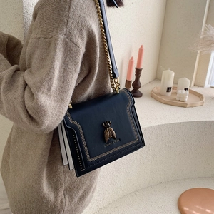 Elegant black leather crossbody bag with gold bee hardware and chain strap for women