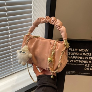 Pink pleated leather shoulder bag with golden chain and fluffy charm accessory