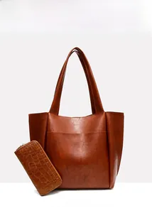 Detail view of large brown vintage leather tote bag with matching embossed wallet
