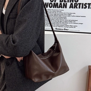 Retro dark brown shoulder bag in faux leather texture styled on a model in gray blazer