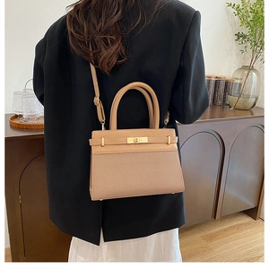 Detail view of the khaki canvas and leather crossbody bag with metal turn-lock closure