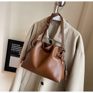 Détail du sac en cuir grainé marron foncé avec cordon et bandoulière réglable