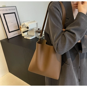 Detailed macro of the textured brown leather bag with a stylish gold metal buckle strap