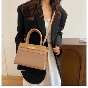 Detail of khaki leather and woven fabric handbag with gold-tone buckle and crossbody strap