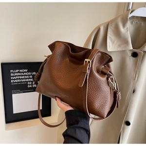 Détail du sac en cuir marron caramel avec cordon de serrage et boucle en métal doré