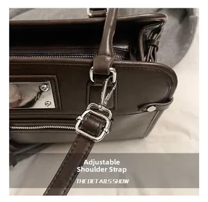 Detail of dark coffee leather bag with adjustable shoulder strap and silver hardware