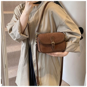 Close-up of brown frosted leather shoulder bag with gold buckle and adjustable strap