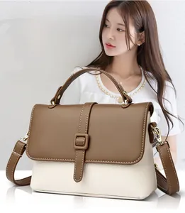 Detail of lychee pattern leather messenger bag with top handle and gold hardware