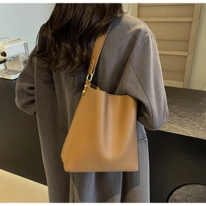Detail of tan lychee grain leather tote with gold hardware and adjustable strap