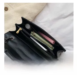 Internal view of black crossbody bag showing spacious compartments with everyday essentials