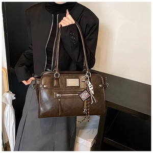 Detail of a dark brown vintage satchel with a front zipper pocket and matte leather texture