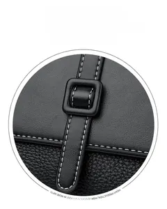Detail of black pebbled leather messenger bag with white stitching and buckle closure