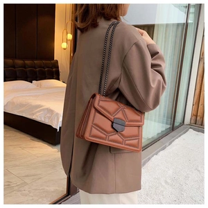 Detail of vintage brown chain crossbody bag with geometric stitching and metal clasp