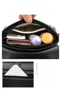 Detail view of the black crossbody bag showing internal compartments and rear zipper pocket