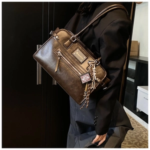 Detailed view of vintage dark brown crossbody bag with matte finish and book pendant