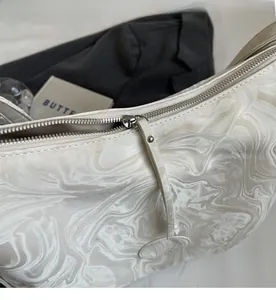 Detailed macro view of smooth silver metal zipper and marble pattern on tote bag