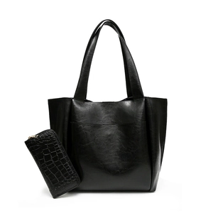 Modern black faux leather tote bag and crocodile pattern wallet set on white background
