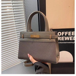 Detail view of the gray-green textured fabric and leather splicing on the stylish handbag