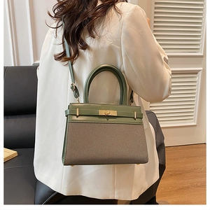 Detail of green leather and beige twill crossbody bag with golden twist lock