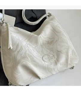 Detailed macro view of cream marble-textured tote bag with soft leather finish