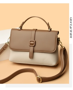 Close-up of contrast crossbody bag showing white pebble grain leather and gold hardware
