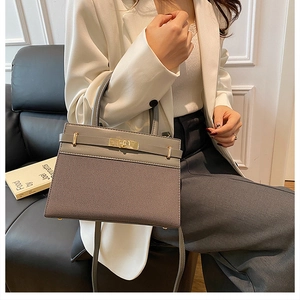 Close-up of elegant grey leather patchwork handbag with gold twist lock and handle