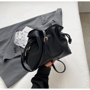 Détail du sac seau en cuir grainé noir avec lettrage doré et fermeture à cordon