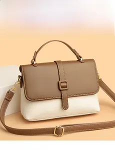Close-up of two-tone luxury messenger bag with cream pebble leather and brown flap