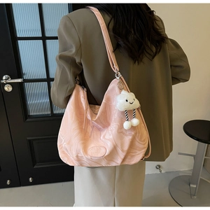 Macro view of light pink marbled hobo bag with cloud charm and shoulder strap