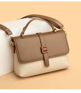 Detail of two-tone luxury crossbody bag with brown flap and cream pebble leather texture