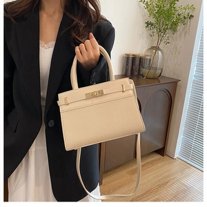 Chic cream structured handbag shown on model featuring woven texture and smooth leather trim