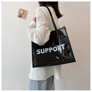 Detail of transparent black tote bag with white SUPPORT text and shiny PVC material finish