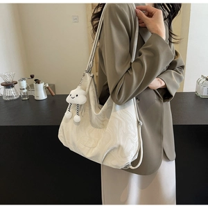 Detail of marble pattern tote bag with plush cloud charm on a shoulder strap