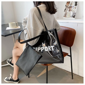 Macro detail of black transparent PVC tote bag with white SUPPORT text and inner pouch