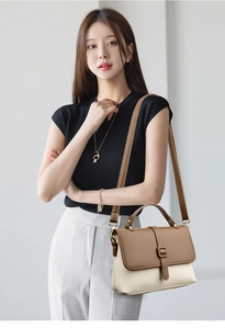 Close-up of contrast brown and beige leather satchel bag with fine pebble grain texture