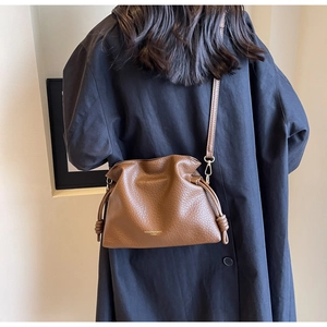Détail du sac bandoulière en cuir grainé marron avec cordon de serrage élégant