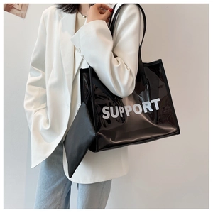 Detail of transparent PVC tote bag with black inner pouch and white SUPPORT lettering