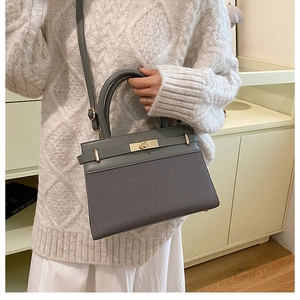 Detail view of charcoal grey handbag with diagonal textured finish and metal clasp