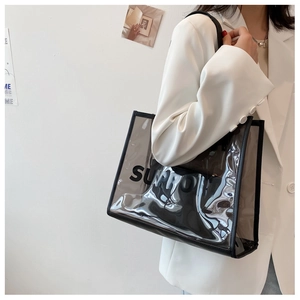 Detail view of large transparent PVC tote bag with black trim and bold letter print