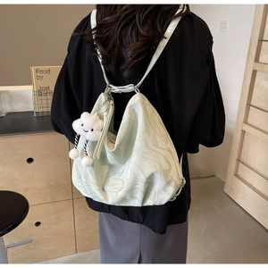 Close-up of marble pattern tote bag featuring a white plush cloud charm and soft fabric
