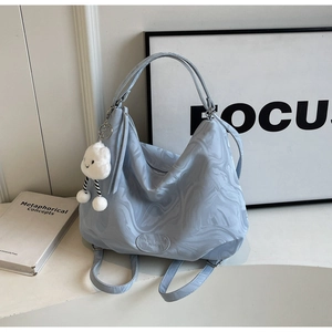 Detail of light blue marble tote bag featuring Muon Shark logo and cloud charm